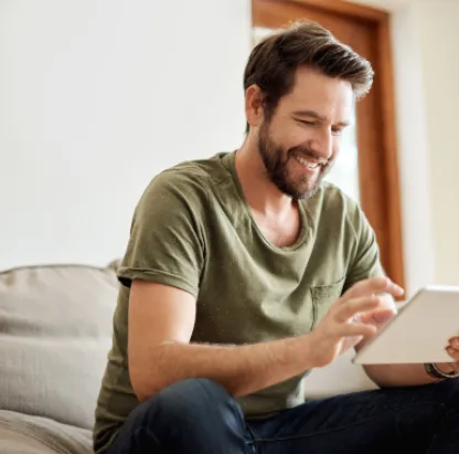 Man in sofa kijkt op tablet